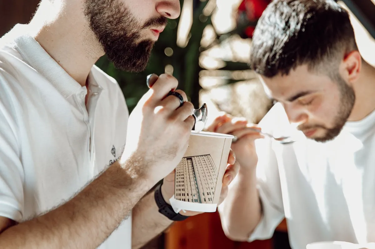 Dos baristas catando café en taza